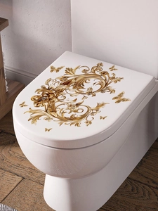 Detailed view of golden butterfly and baroque floral wall stickers on a ceramic surface