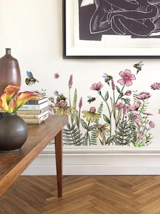 Détail de stickers muraux abeilles et fleurs sauvages sur un mur blanc de salon
