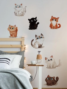 Detail view of seven cute cartoon cat wall stickers in a cozy bedroom setting