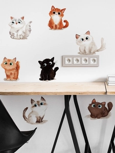 Detailed view of cute cartoon cat wall stickers on white wall above a wooden desk
