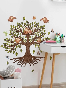 Detail of tree wall sticker with owls and butterflies in a cozy nursery room setting