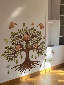 Detail view of decorative wall sticker with brown tree, owls, and colorful butterflies