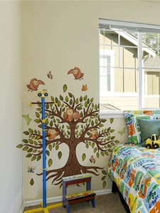 Detail of owl and butterfly wall decals on a brown tree for nursery room decor
