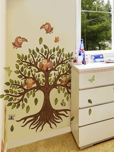 Detail of owl and butterfly wall stickers on a decorative tree in a home bedroom