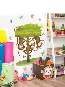 Detail showing a colorful cartoon tree wall sticker with monkeys and butterflies in a nursery