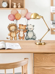 Detail of cartoon lion, tiger and bear with balloons on a nursery wall above a desk