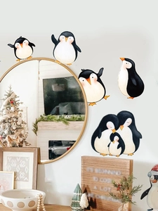 Detailed view of hand-painted penguin wall stickers on a mirror surface for home decor