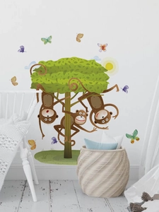 Detail of cute monkeys on a green tree wall sticker with butterflies for nursery