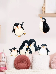 Nursery wall scene with cute cartoon penguin family stickers on a soft pink wall