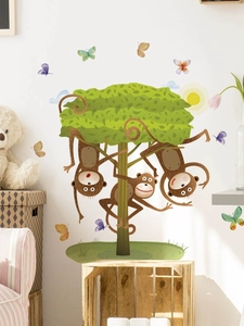 Nursery wall sticker with three brown monkeys climbing a lush green tree and butterflies