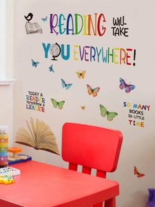 Détail de papillons colorés et de stickers muraux avec citations dans un coin d'étude chaleureux