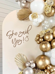 Detailed view of metallic gold balloons with dried palm leaves for engagement decor