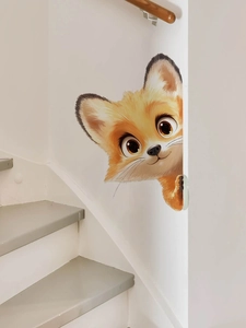 Gros plan d'un autocollant mural renard mignon avec de grands yeux au coin d'un mur blanc