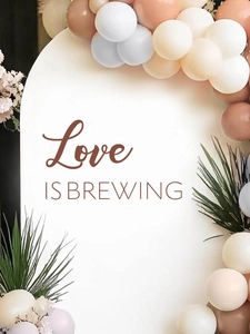 Détail d'un sticker mural DIY avec texte Love is Brewing, arche de ballons et plantes