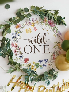 Close-up of wild ONE floral wreath backdrop with golden Happy Birthday banner decoration
