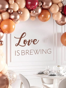 Décor de fête élégant avec arche de ballons 'Love IS BREWING' en or rose et bordeaux