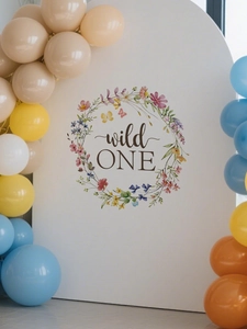 Detail view of wild ONE floral birthday arch backdrop with colorful party balloons decor