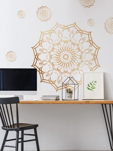 Detail von goldenen Mandala-Wandstickers auf weißer Wand über einem Schreibtisch