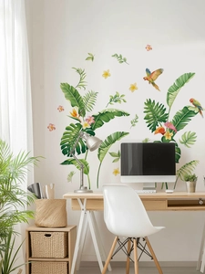 Detail of tropical plant wall stickers with green leaves and parrots on a white wall