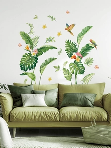 Detail of tropical rainforest wall stickers with parrots and leaves above a sofa
