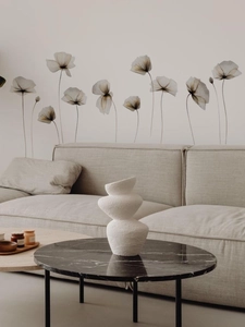 Détail de stickers muraux floraux de style rayons X sur un mur de salon gris moderne