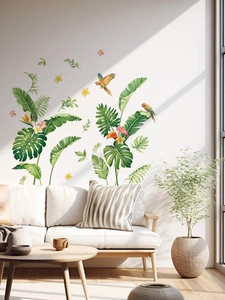 Detail of tropical plant wall decals with parrots and monstera leaves in a living room