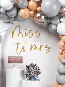 Detail of baby gender reveal balloon arch with Miss to Mrs decal on white backdrop