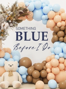 Detail of blue and beige balloon arch decoration with teddy bear and dried flower accents