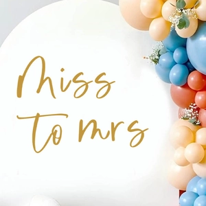 White arch backdrop with gold Miss to Mrs lettering and pastel balloon arch decor