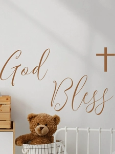Detail view of God Bless lettering and cross wall decal in a cozy bedroom setting