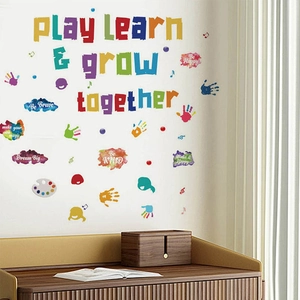 Stickers muraux colorés Play Learn & Grow Together pour chambre d'enfant sur mur blanc