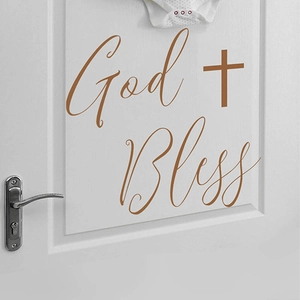 God Bless self-adhesive brown wall decal with cross symbol on a white door