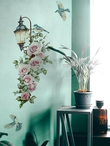 Detalle de adhesivo de pared farola floral con rosas rosas y pájaros sobre pared verde