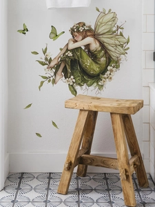 Detail of green forest fairy wall sticker with wings and butterflies on white wall