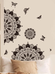 Detail of black mandala wall stickers with butterfly decals on a cozy bedroom wall