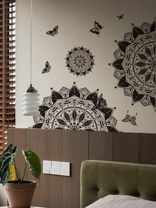 Detailed view of black mandala wall decals and butterfly stickers in a cozy bedroom setting