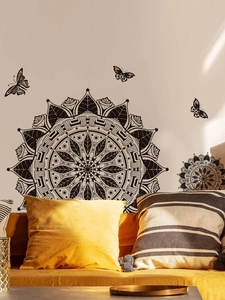 Detail view of black mandala wall decal with butterflies above a sofa in a living room