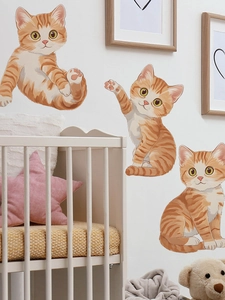 Detailaufnahme von drei süßen orangefarbenen Katzen-Wandtattoos in einem Babyzimmer