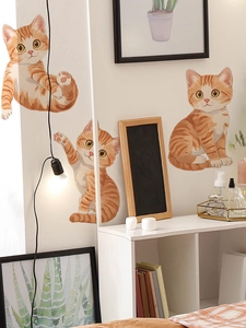 Detailansicht von drei süßen orangefarbenen Katzen-Wandstickern auf einer weißen Wand