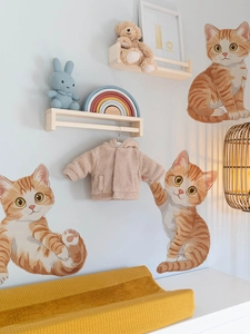 Detailansicht von drei süßen orangefarbenen Kätzchen-Wandstickern im warmen Schlafzimmer