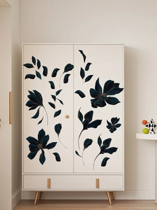 Détail de stickers muraux floraux sombres avec liserés dorés sur une armoire minimaliste