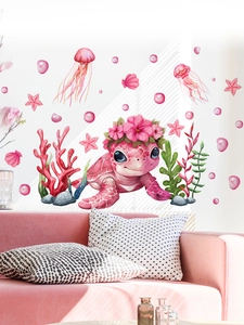 Detail of pink cartoon sea turtle wall decals in a cozy nursery room setting