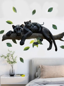 Detail of black panther wall stickers on a modern bedroom wall with green leaf accents