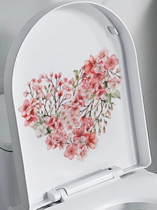Detail view of pink floral heart-shaped PVC sticker on a white toilet lid surface