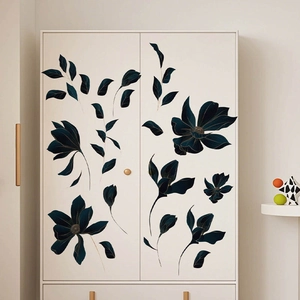 Stickers muraux fleurs bleu marine et or appliqués sur une armoire blanche minimaliste
