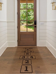 Close-up of black hopscotch wall stickers with numbers 1 to 10 on indoor corridor floor