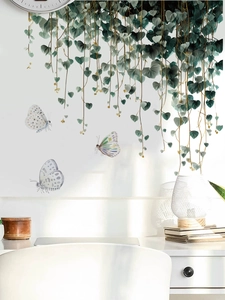 Detail of hanging green vine wall stickers with watercolor butterflies in a bedroom setup