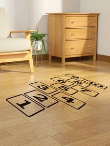 Detail view of numbered hopscotch floor stickers from 1 to 10 on light wood flooring