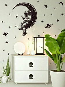 Black space wall decals featuring an astronaut on a crescent moon with stars and planets