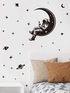 Detail of black PVC astronaut wall stickers with moon and stars in a modern bedroom